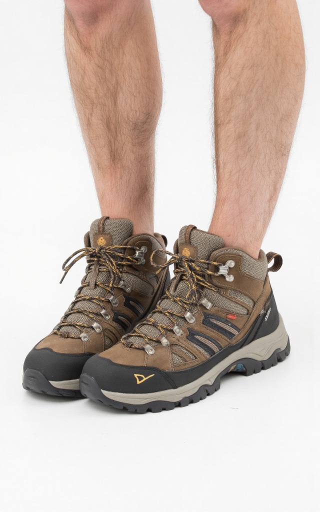 A male model wearing Hiking boots, against a white background, with a close   up of the feet